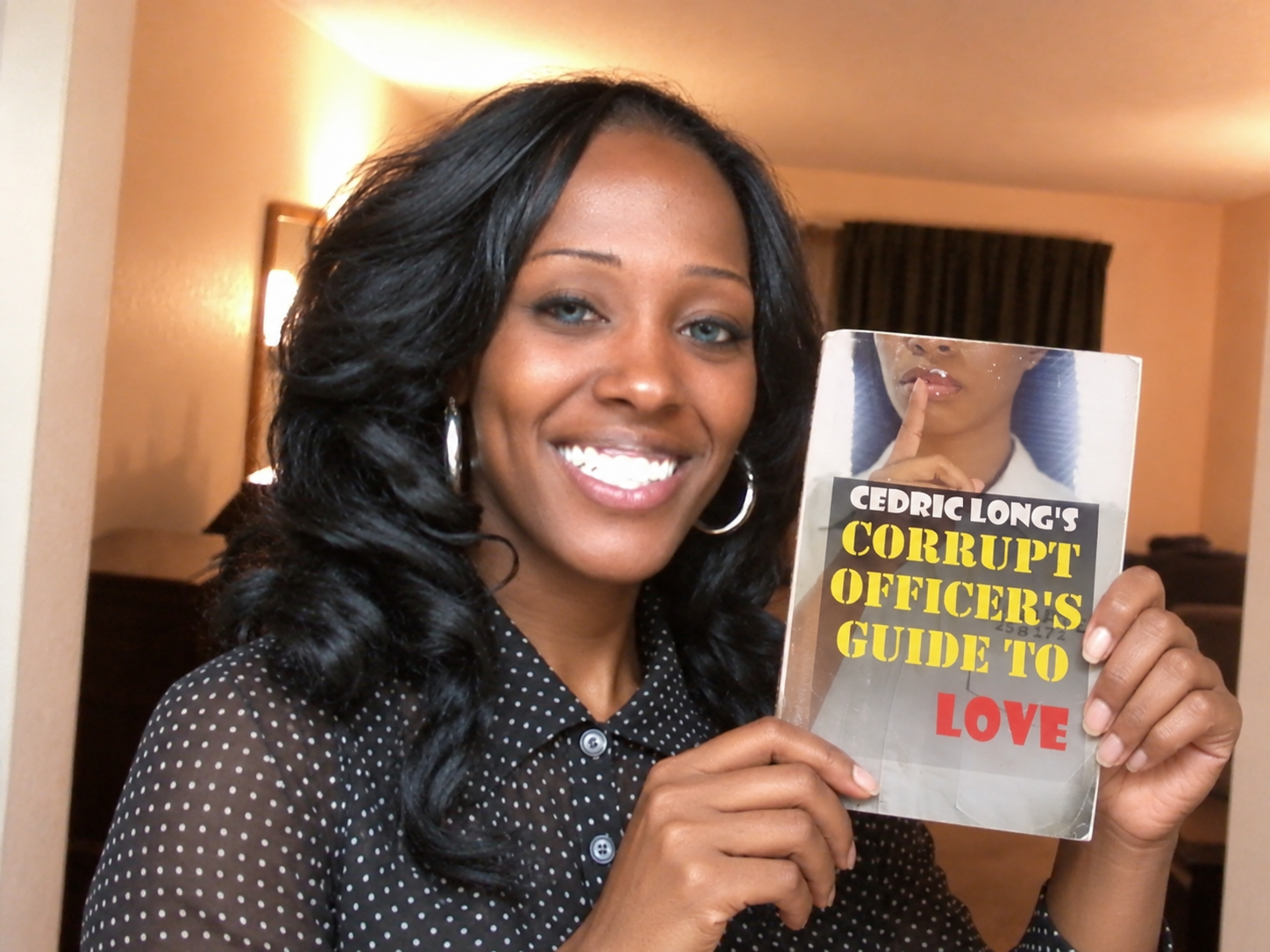 Reader holding Corrupt Officer's Guide to Love