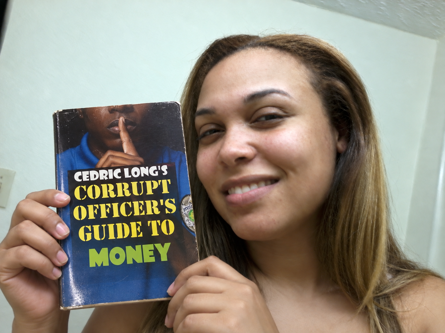 Reader holding Corrupt Officer's Guide to Money
